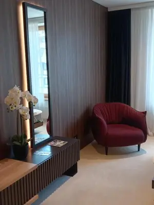 a living room with a red chair and a mirror at WOODSIDE - Luxury Apartment & SPA in Kopaonik