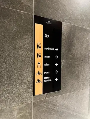 a sign on the side of a wall with arrows at WOODSIDE - Luxury Apartment & SPA in Kopaonik