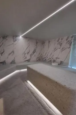 a bathroom with a tub and a marble wall at WOODSIDE - Luxury Apartment & SPA in Kopaonik