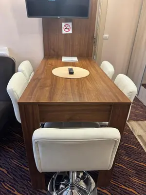 a wooden table with white chairs and a tv on top at Vila Zvončica Apartman Z12 in Kopaonik
