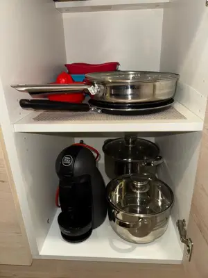 a kitchen drawer with pots and pans on a shelf at Vila Zvončica Apartman Z12 in Kopaonik