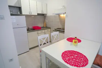 a kitchen with a white table and white appliances at SokoPan in Soko Banja