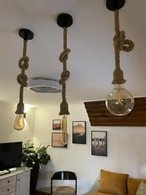 a living room with three lights hanging from the ceiling at Kućerak na Kopu in Kopaonik