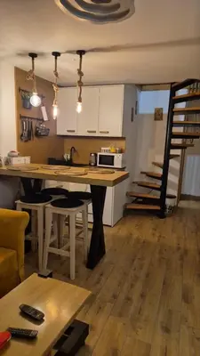 a kitchen with a table and some chairs in a room at Kućerak na Kopu in Kopaonik