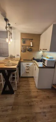 a kitchen with a table and a counter top at Kućerak na Kopu in Kopaonik