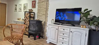 a television on a white dresser in a living room at Kućerak na Kopu in Kopaonik
