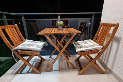 a wooden table and two chairs on a balcony at Apartman S16 Vrnjačka Banja in Vrnjačka Banja
