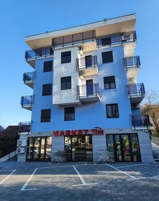 a building with a parking lot in front of it at Apartman S16 Vrnjačka Banja in Vrnjačka Banja
