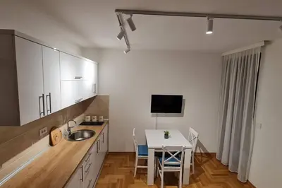 a kitchen with a sink and a table with a tableablish at Apartman S16 Vrnjačka Banja in Vrnjačka Banja