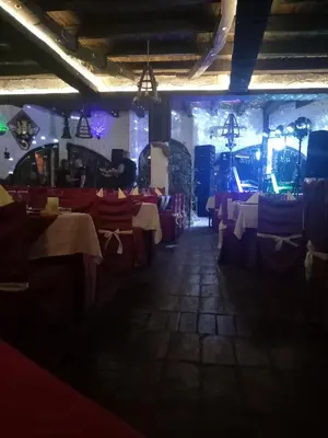a dining room with red and white tables and lights at BUMBAR ETNO DVORAC in Tekija