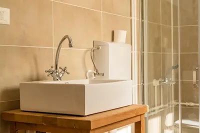a bathroom with a white sink and a shower at Mir i planina in Bučje