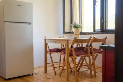 a kitchen with a table and chairs and a refrigerator at Mir i planina in Bučje