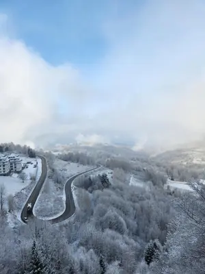 a car driving down a road in the snow at Dux Apartmani - Milmari, Kopaonik in Cajetina