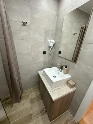 a bathroom with a sink and a mirror at Dux Apartmani - Milmari, Kopaonik in Cajetina