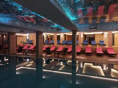 a pool with chairs and tables in a building at Dux Apartmani - Milmari, Kopaonik in Cajetina