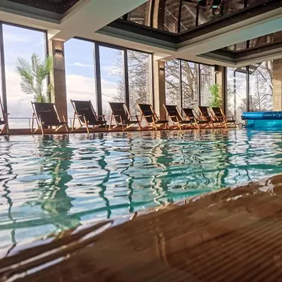a swimming pool with chairs in a building at Dux Apartmani - Milmari, Kopaonik in Cajetina