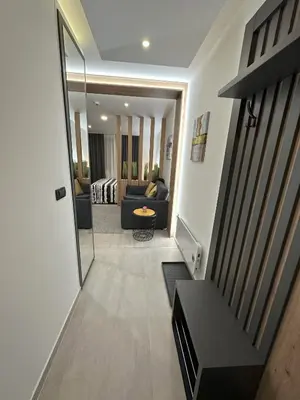 a hallway leading to a living room with a mirror at Dux Apartmani - Milmari, Kopaonik in Cajetina