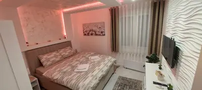 a small bedroom with a bed and a television at GOLD APARTMANI in Prokuplje