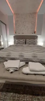 a large bed with white pillows on top of it at GOLD APARTMANI in Prokuplje
