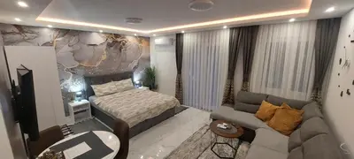 a small bedroom with a bed and a couch at GOLD APARTMANI in Prokuplje