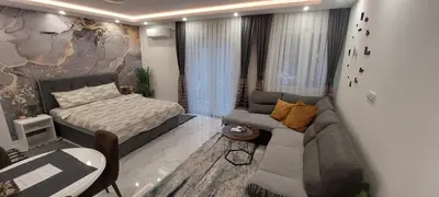 a living room with a couch and a bed in it at GOLD APARTMANI in Prokuplje