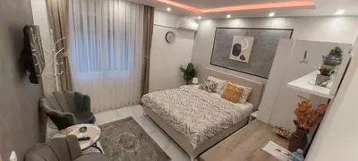 a small bedroom with a bed and a table at GOLD APARTMANI in Prokuplje