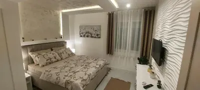 a small bedroom with a bed and a television at GOLD APARTMANI in Prokuplje
