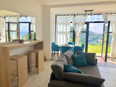 a living room with a couch and a table at Cozy Mountain View Apartment in Kopaonik
