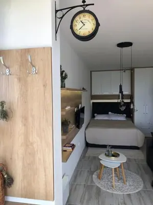 a bedroom with a bed and a clock on the wall at Cozy Mountain View Apartment in Kopaonik