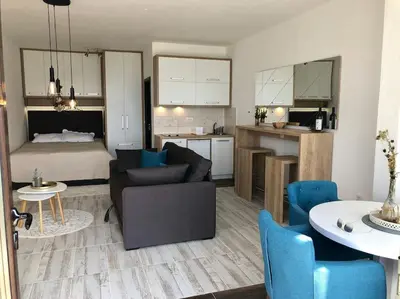 a living room and kitchen with a couch and a table at Cozy Mountain View Apartment in Kopaonik