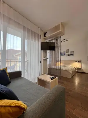 a living room with a couch and a large window at Apartman Sita in Vrnjačka Banja