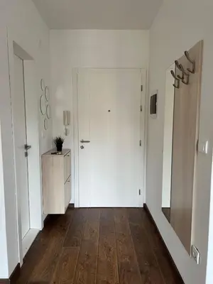 a hallway with a white door and a wooden floor at Apartman Sita in Vrnjačka Banja