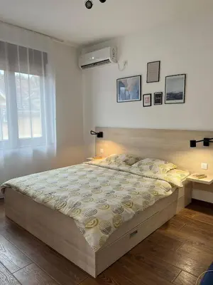 a large bed in a bedroom with a window at Apartman Sita in Vrnjačka Banja
