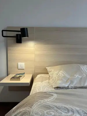 a bedroom with a bed with a nightstand next to it at Apartman Sita in Vrnjačka Banja