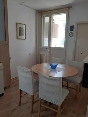 a dining room with a wooden table and chairs at Apartman Oskar in Bor