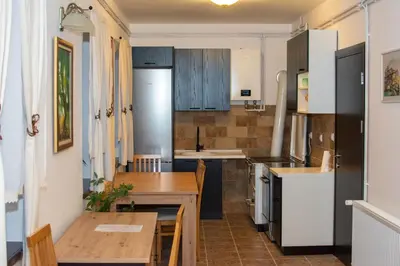 a kitchen with a table and a dining room at Konačište Zaplanjsko ognjište in Donji Dušnik