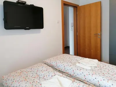a bedroom with a bed with a tv on the wall at Apartman Andjelkovic in Soko Banja