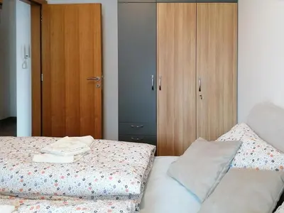 a bedroom with a bed and a wooden cabinet at Apartman Andjelkovic in Soko Banja
