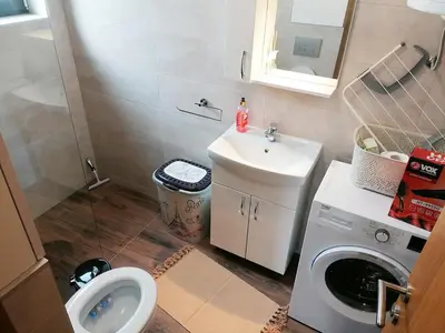 a small bathroom with a sink and a washing machine at Apartman Andjelkovic in Soko Banja