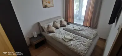 a bedroom with a bed with pillows and a window at Apartman Andjelkovic in Soko Banja
