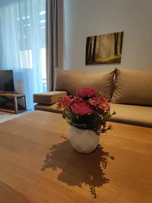 a vase with flowers on a table in a living room at Gondola Studio Brzeće Kopaonik in Brzeće