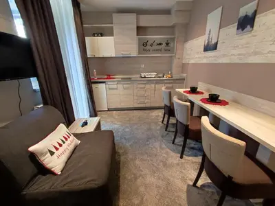 a living room with a couch and a table with chairs at Gondola Studio Brzeće Kopaonik in Brzeće