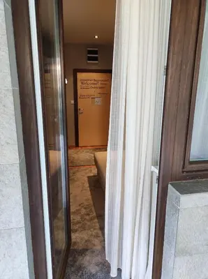 a bathroom with a shower curtain and a door at Gondola Studio Brzeće Kopaonik in Brzeće