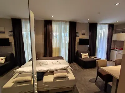 a bedroom with two beds and a living room at Gondola Studio Brzeće Kopaonik in Brzeće