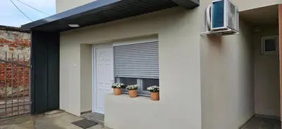 a house with two potted plants on a window at Apartman Sen's in Leskovac