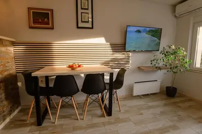a dining room with a table and four chairs at Apartman Sen's in Leskovac