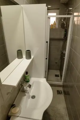 a bathroom with a white toilet and a shower at Apartman Sen's in Leskovac