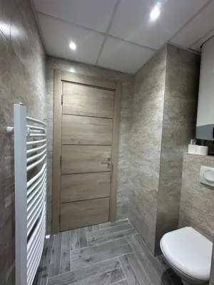 a bathroom with a toilet and a wooden door at MB Apartmani Kopaonik in Kopaonik