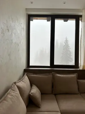 a couch in a living room with a window at MB Apartmani Kopaonik in Kopaonik