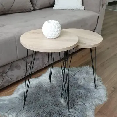a round wooden table in front of a couch at APARTMAN ANDREA in Leskovac